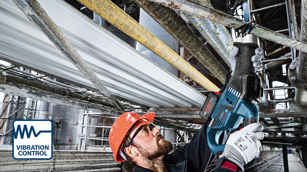 A worker in an orange helmet uses a Bosch Professional tool on metal pipes indoors.